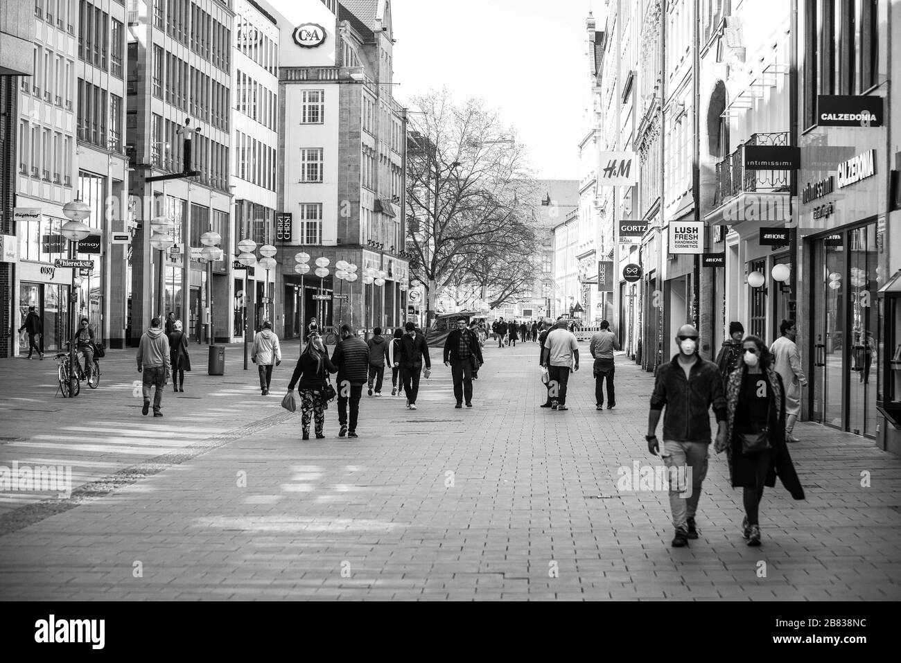 Munich, Bavaria, Germany. 19th Mar, 2020. Two tourists wear face masks in the relatively empty streets in the city center of Munich, Germany. Ordinarily, these streets are filled with tens of thousands from around the world. As a response to the increasingly dire Coronavirus (Sars CoV 2, Covid 19), the state of Bavaria has instituted measures that restrict the operations of various types of businesses that has led to the city center, once filled with tens of thousands of tourists and residents, to become a virtual ghost town, with limited numbers of people in sight. (Credit Image: © Sachelle Stock Photo