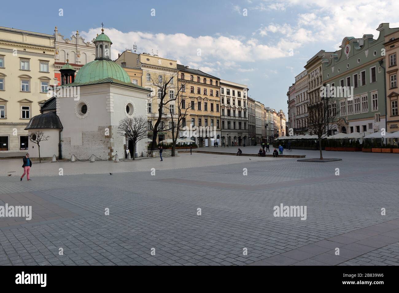 Krakow / Poland - 19 March 2020: Almost empty main market square  to prevent spreed of coronavirus, Saint Marys church, dry hotspot in popular city Stock Photo