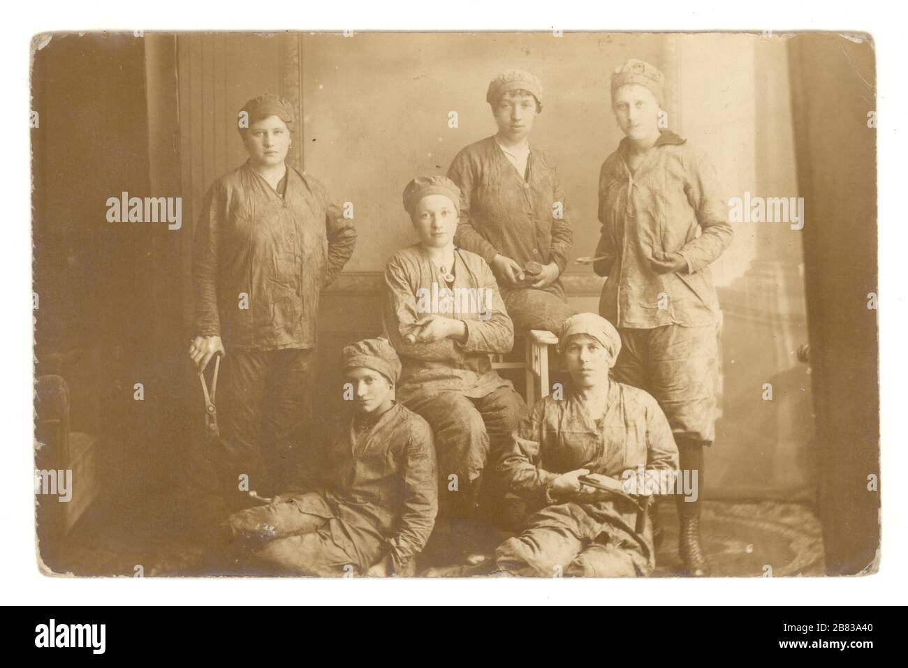 Original WW1 era real photographic postcard of German lady riveters - munitions or dock workers holding rivets, 1914-1918, Germany Stock Photo