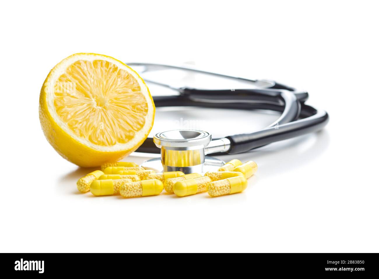 Vitamin capsules. Vitamin C pills, stethoscope and yellow lemon