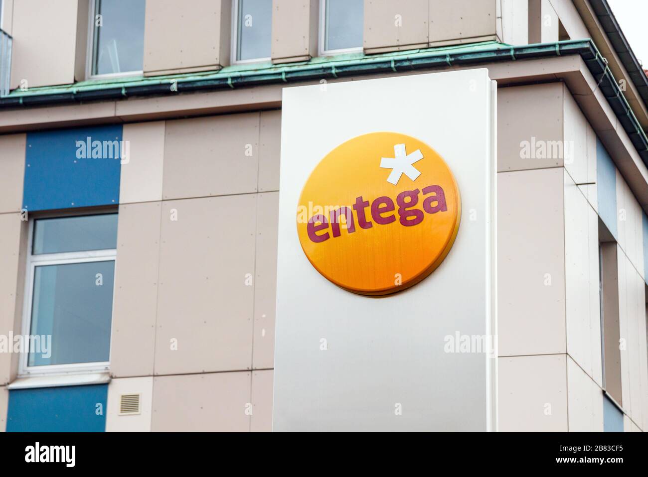 Stand with the Entega logo and a building the background. Entega AG is a German energy supplier based in Darmstadt. Stock Photo
