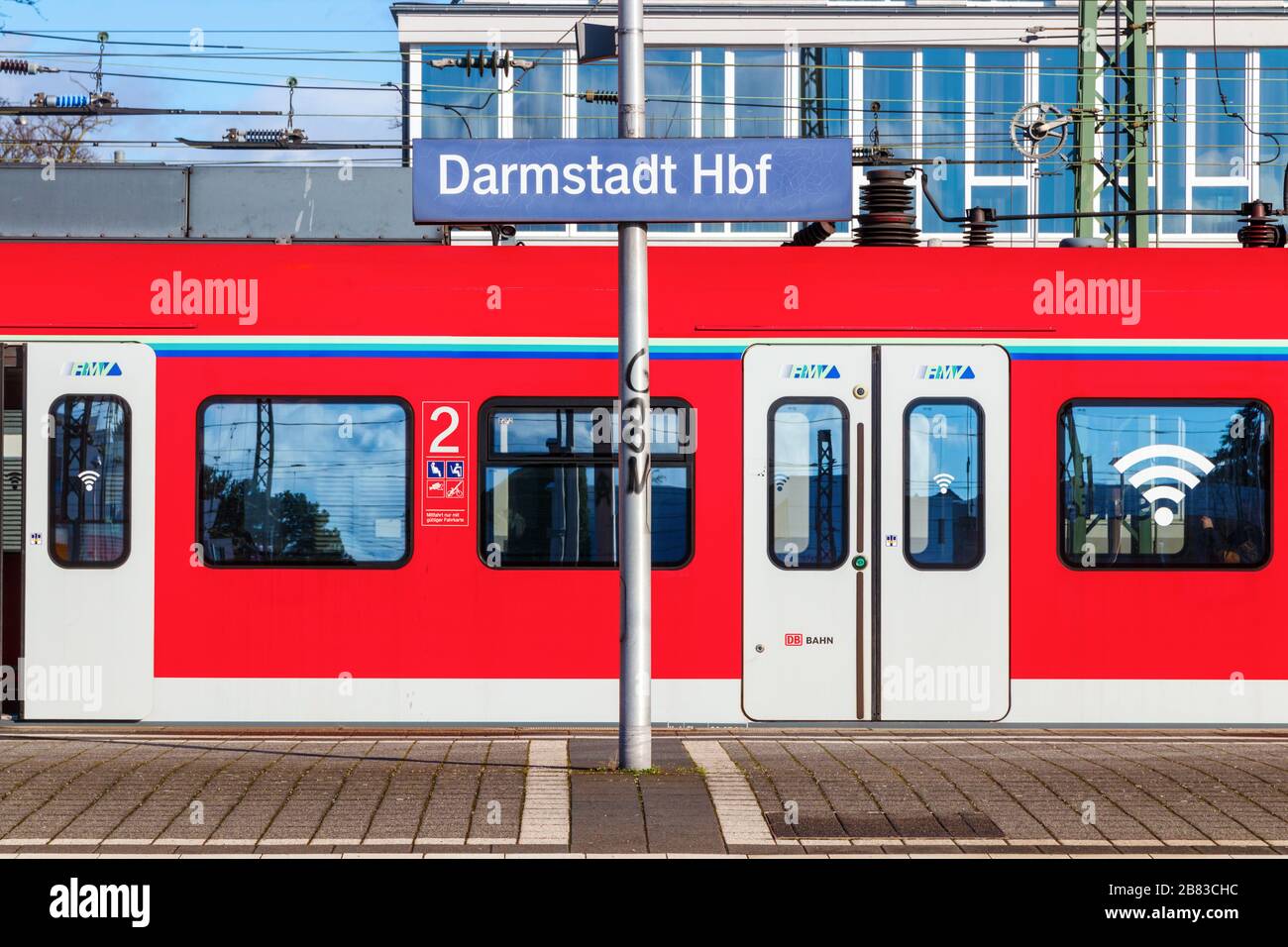 Red, stationary train at a platform of the Darmstadt Hauptbahnhof. Hesse, Germany. Stock Photo