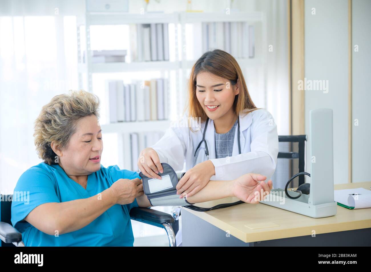 Female doctor measuring blood pressure of senior woman Stock Photo - Alamy