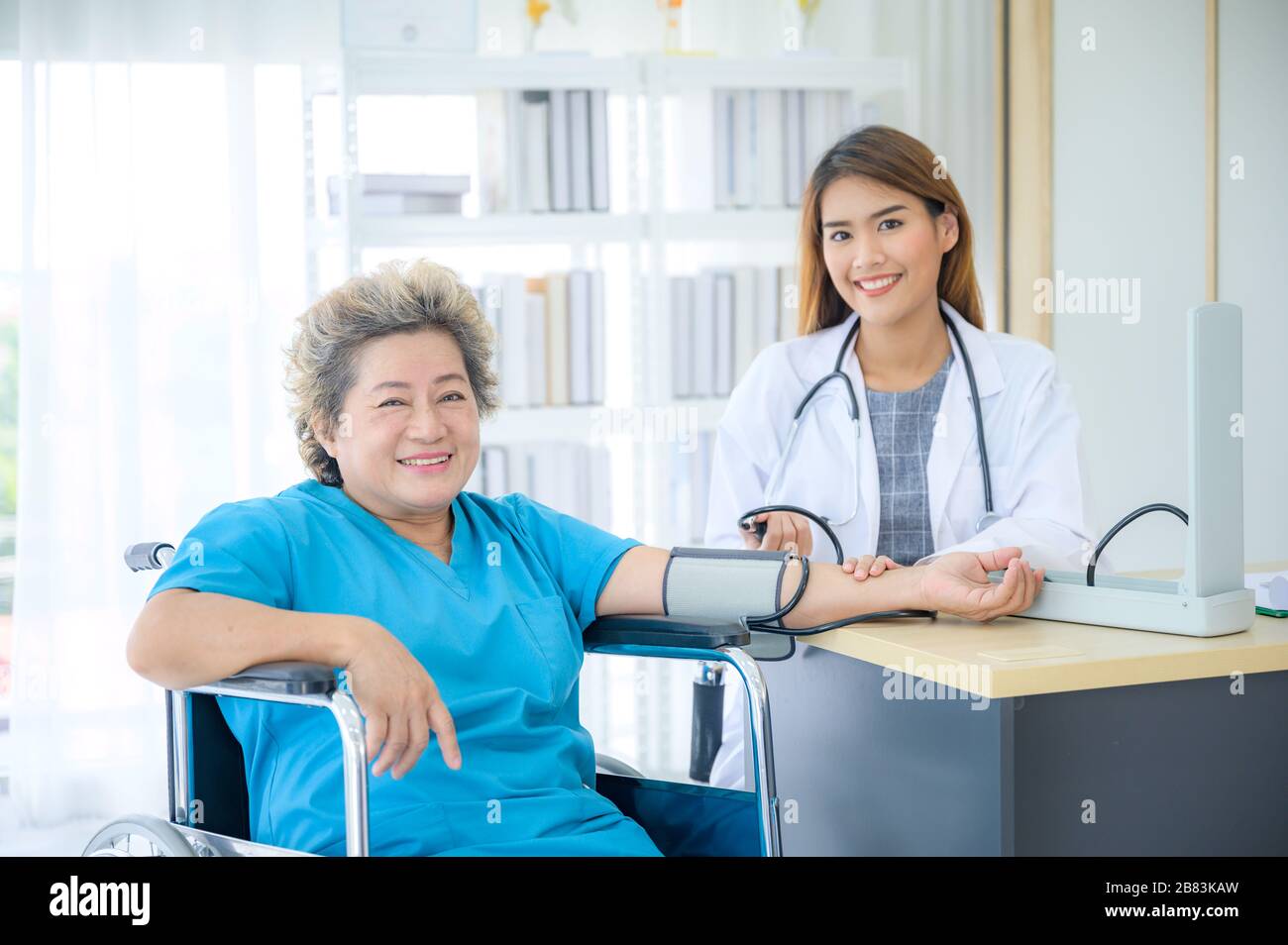 Female doctor measuring blood pressure of senior woman Stock Photo - Alamy
