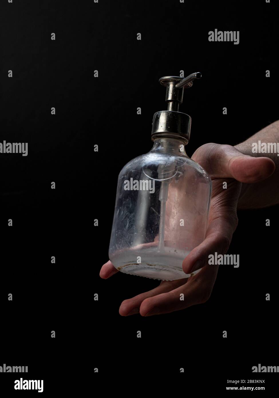 Young man is holding taking giving throwing a soap bottle for washing his hands Stock Photo