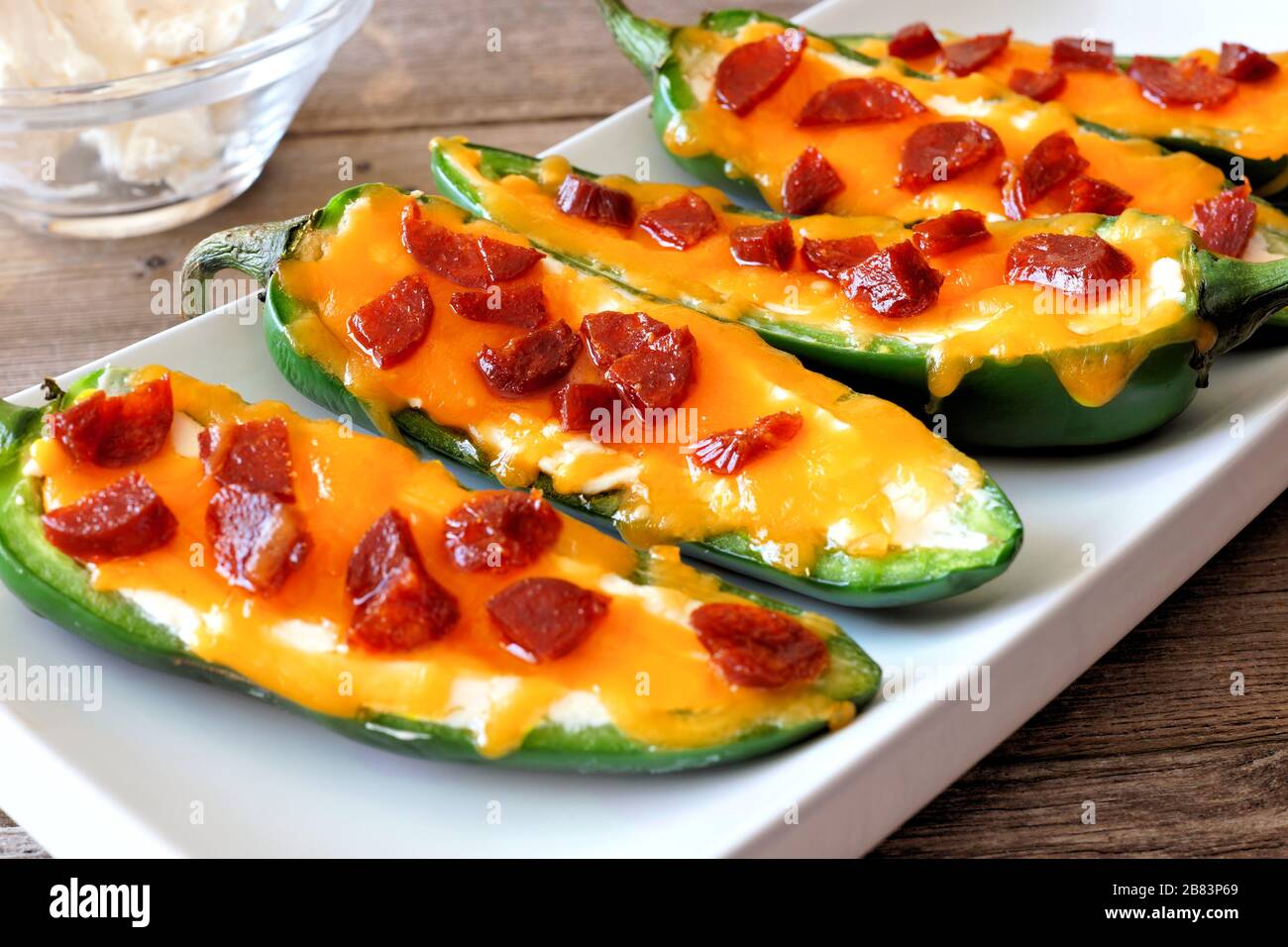 Group of jalapeno poppers with cheese and pepperoni close up on a white