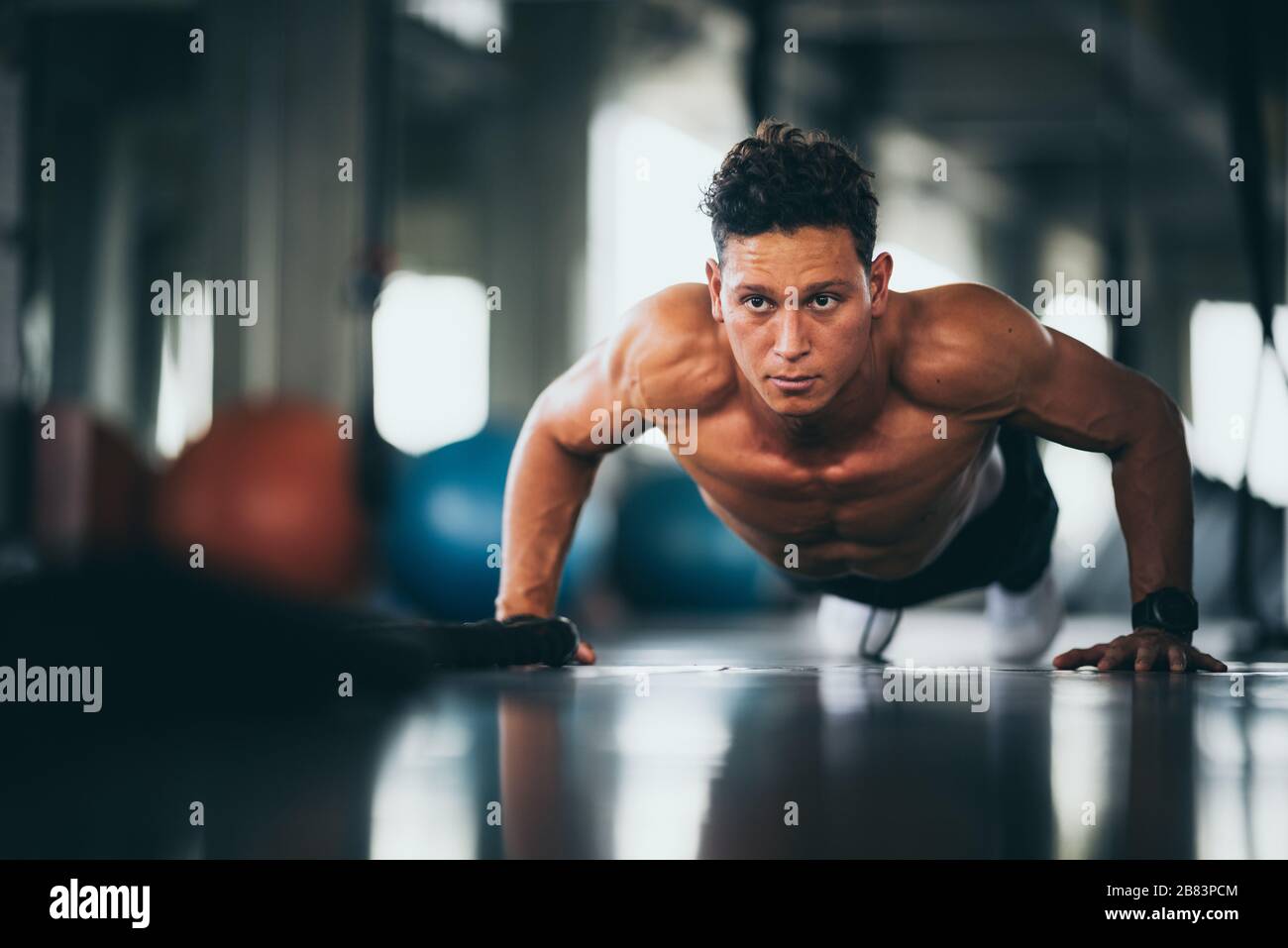 Portrait of a handsome man doing push ups exercise with hand in fitness ...