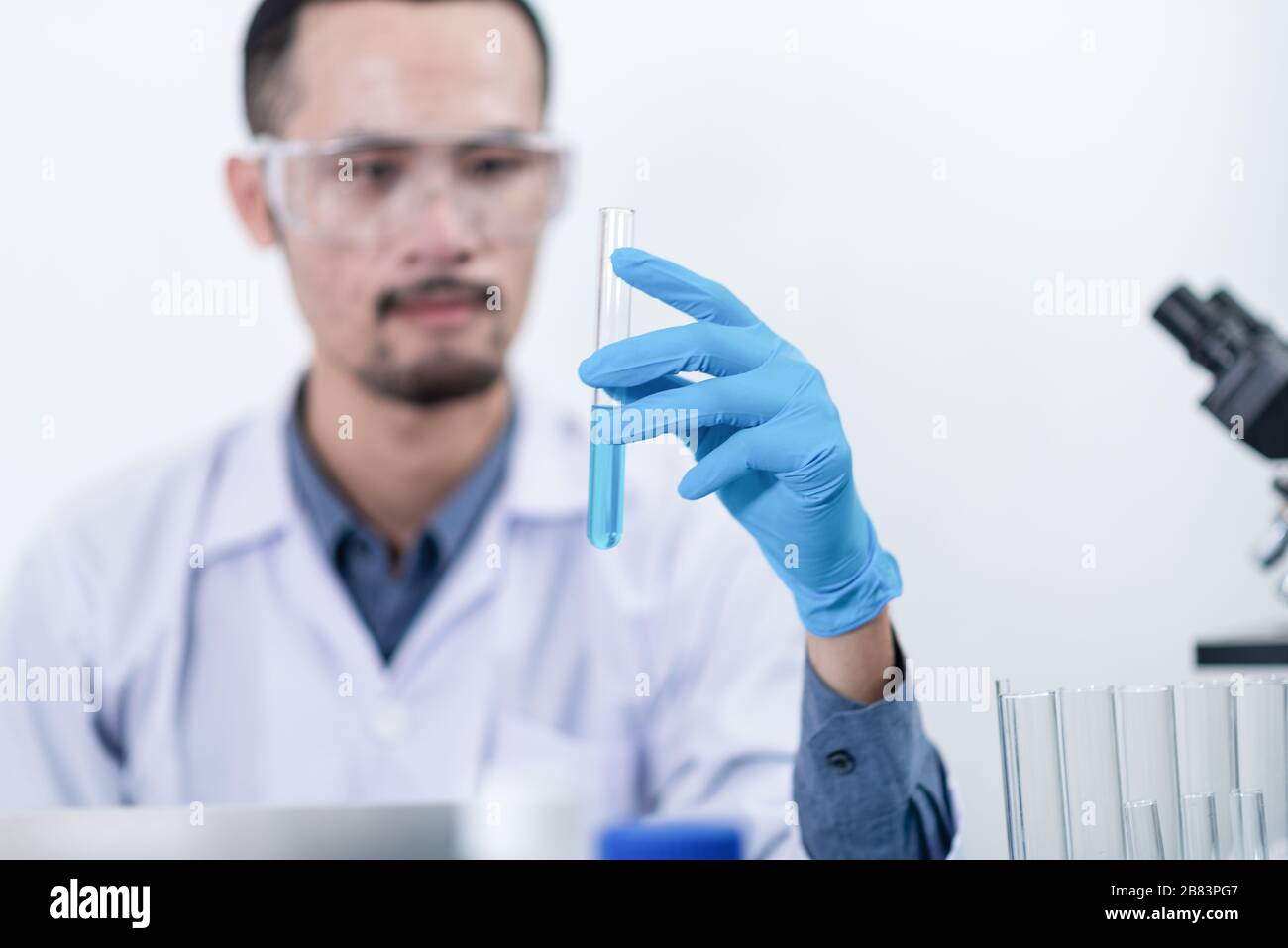 Scientists are studying laboratory chemicals, blue chemicals in tube