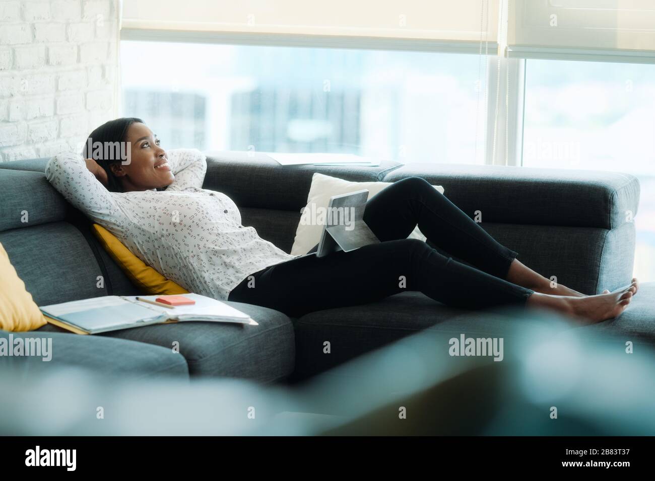 Portrait Of Businesswoman Doing Remote Work On Sofa Stock Photo