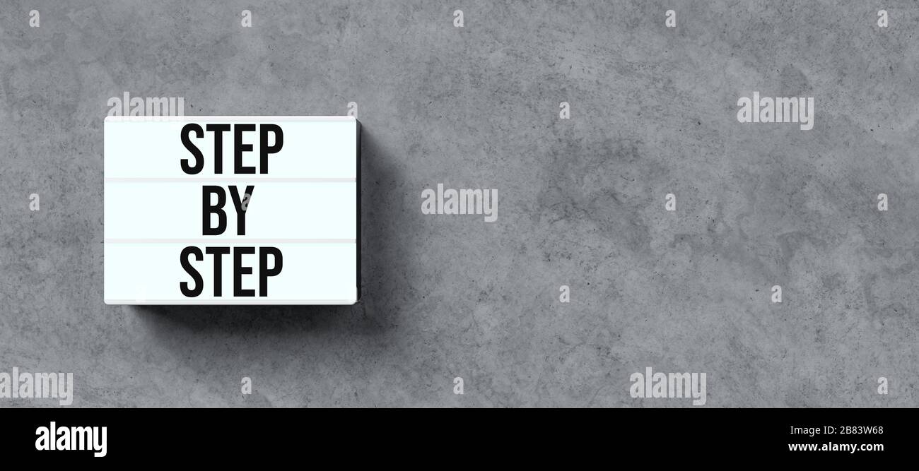 lightbox with message STEP BY STEP on concrete background - 3D rendered ...
