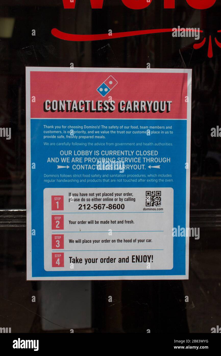 sign at a Domino's location in INwood, new york offering contactless carryout pizza delivery due to the coronavirus covid-19 pandemic Stock Photo