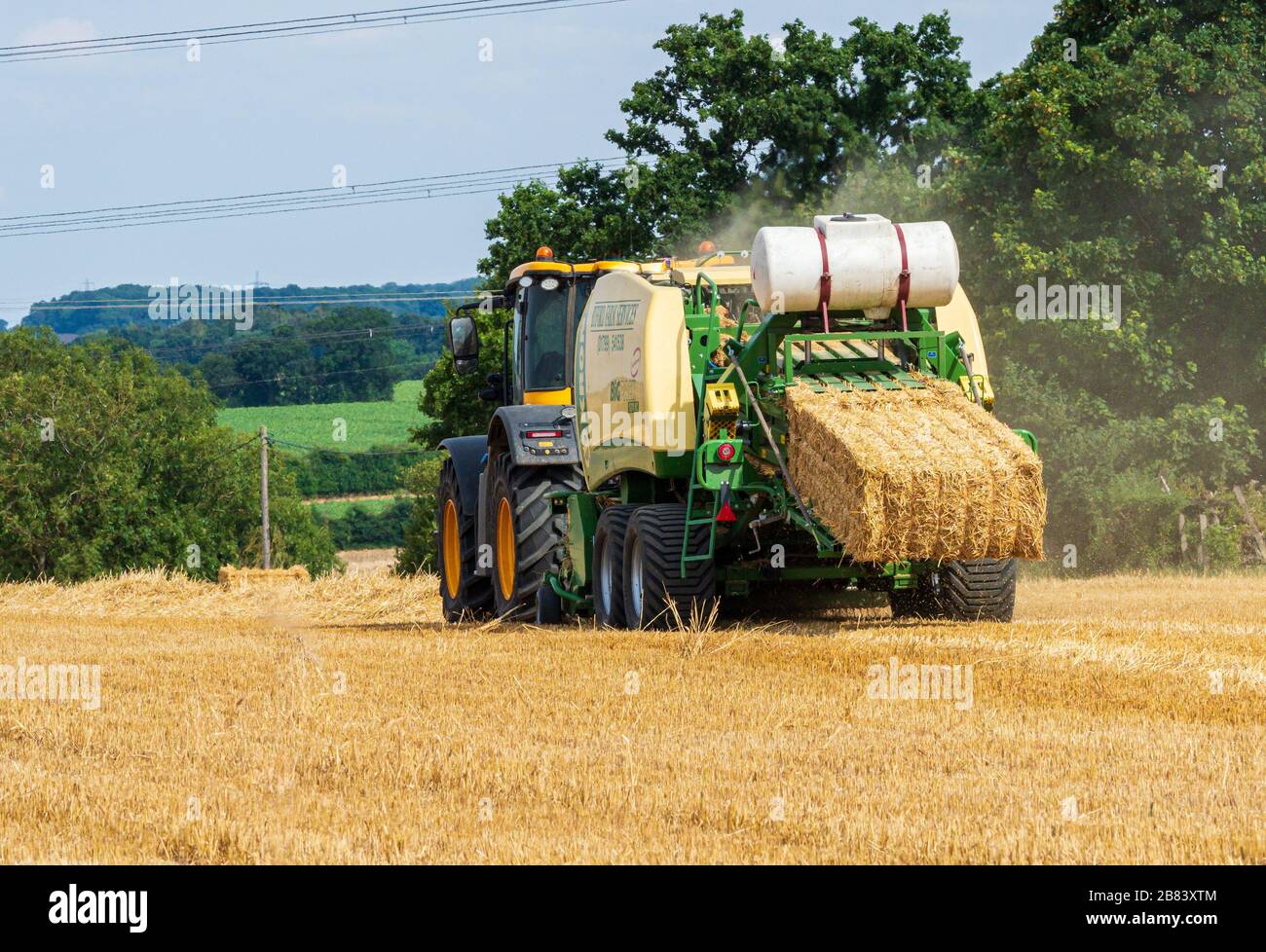 Farm baling machine operating in field Stock Photo