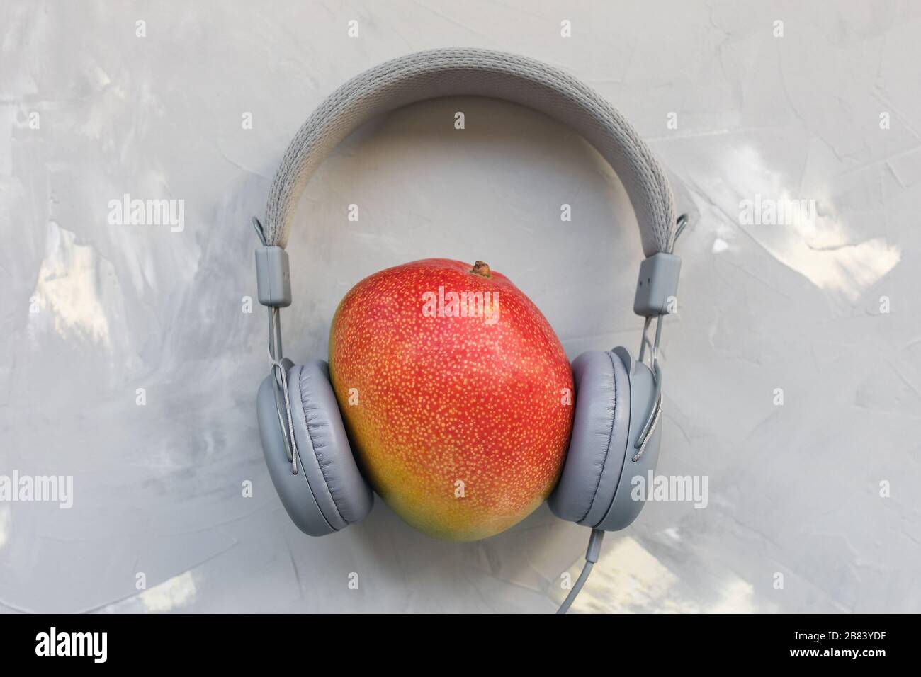 Mango and headphones on gray background. Music and food podcast concept.  Top view, flat lay, copy space Stock Photo - Alamy