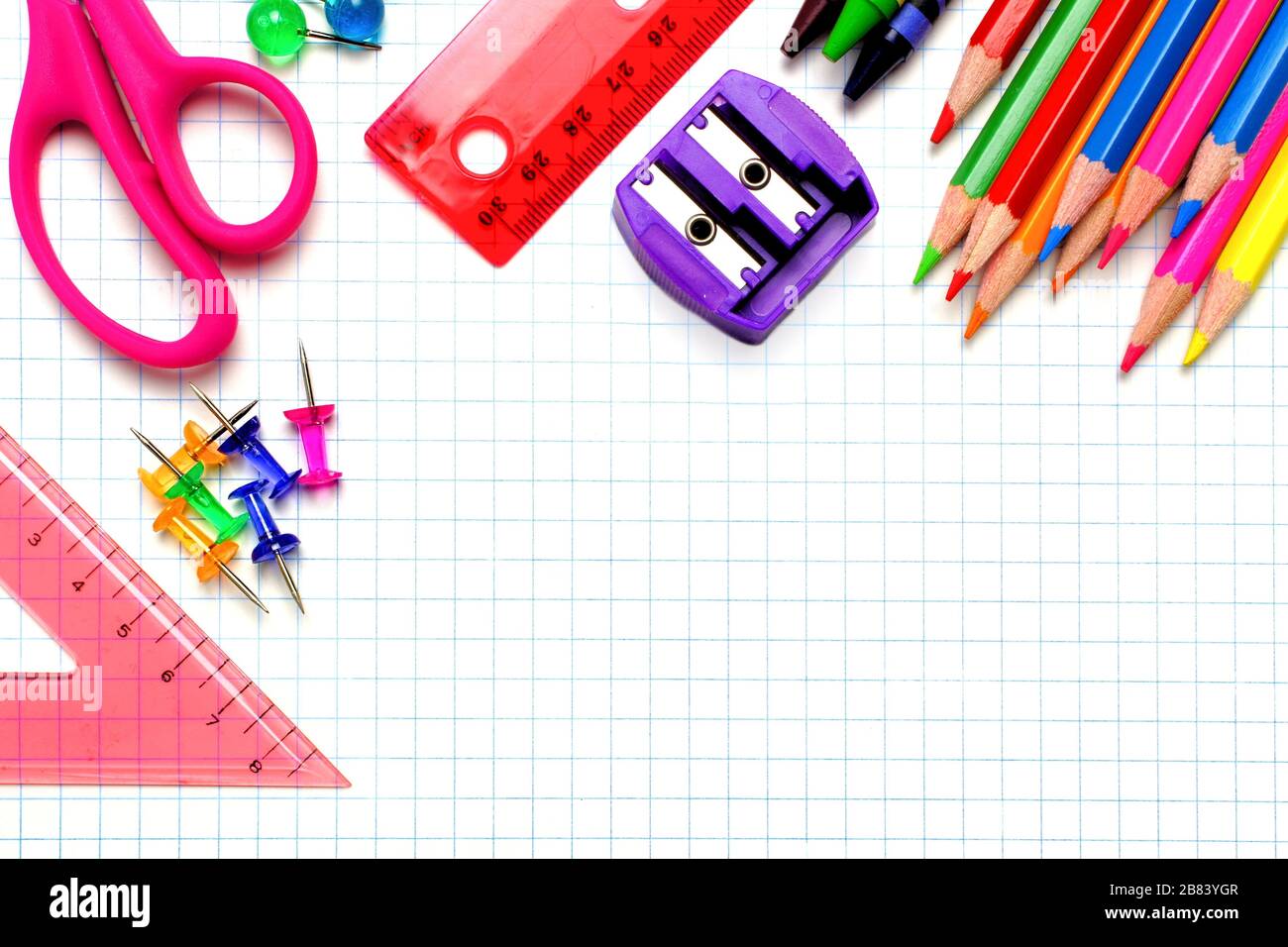 Colorful school supplies corner border over a graphing paper background Stock Photo