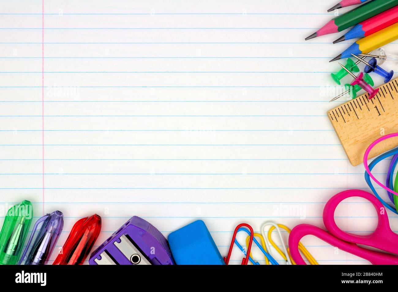Colorful school supplies corner border over a lined paper background Stock Photo
