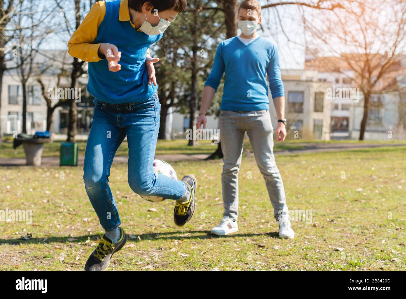 Dad and son playing soccer in park during coronavirus crisis Stock Photo