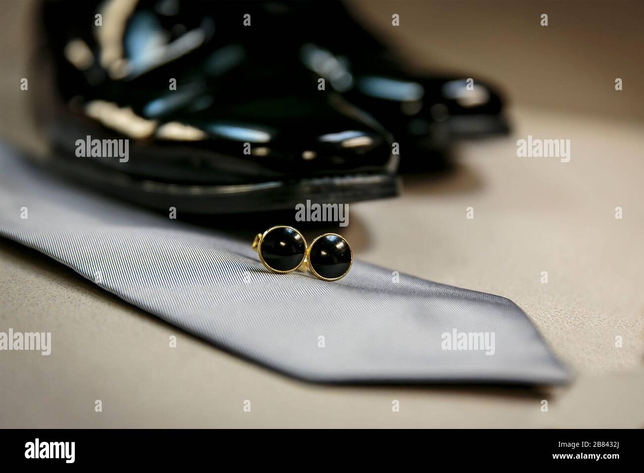 In preparation for a wedding, bridegroom shoes, tie and tie clasp on a table Stock Photo