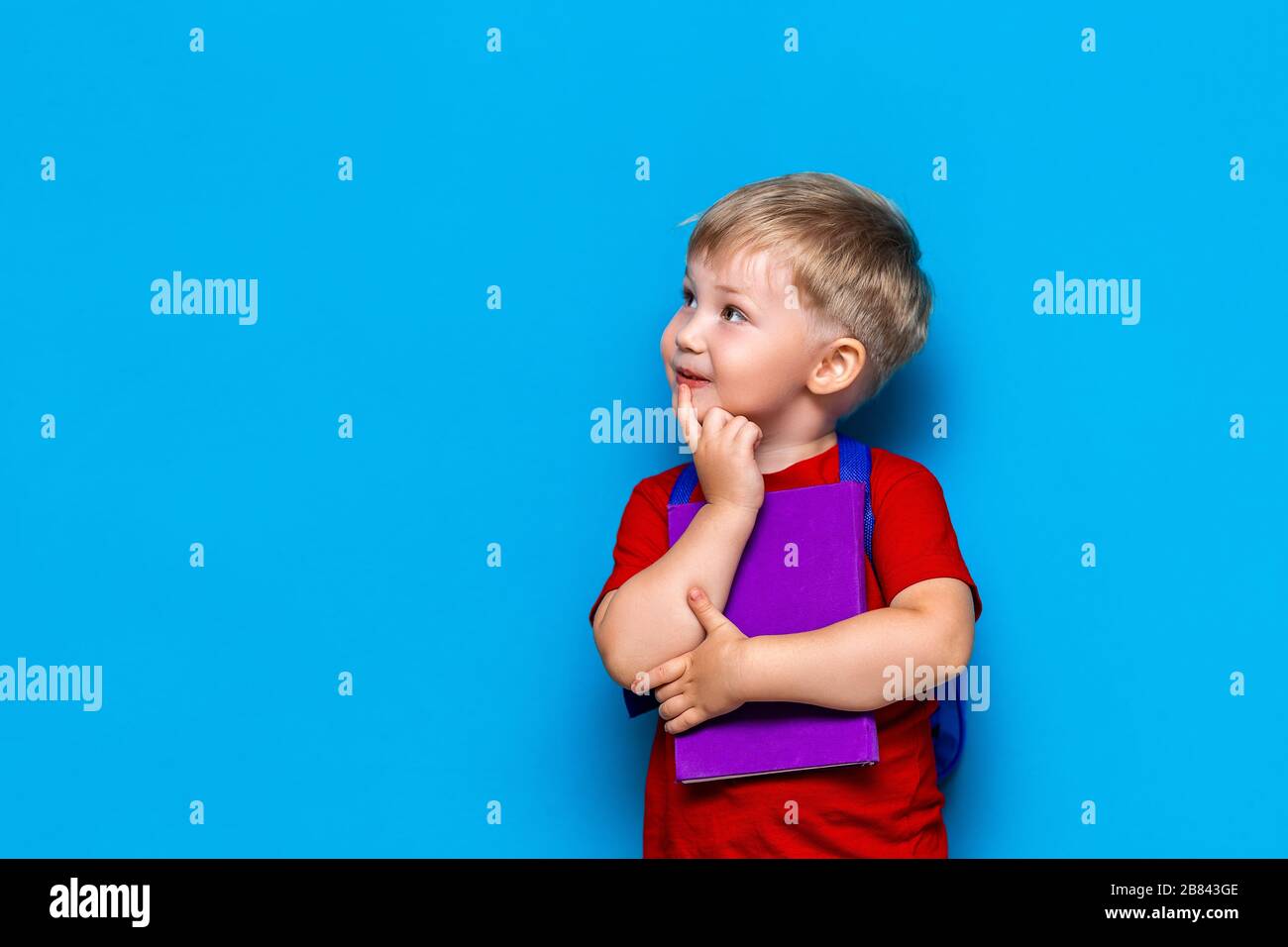 Back to school Portrait of happy surprised kid in glasses isolated on blue background with copy space. new school knowledges Stock Photo