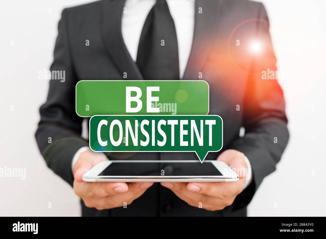 Conceptual hand writing showing Be Consistent. Concept meaning always  behaving or happening in a similar positive way Male human wear formal work  suit Stock Photo - Alamy