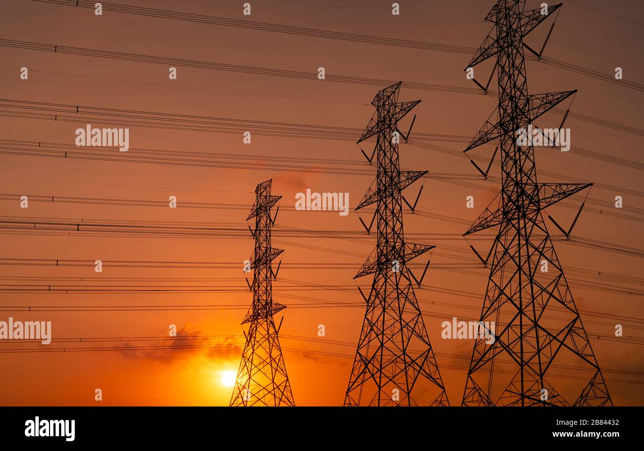 High voltage electric pylon and electrical wire with sunset sky ...
