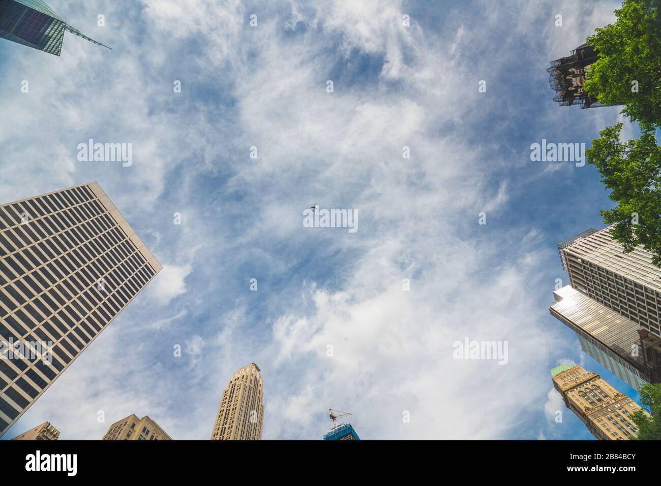 New York City skyscrapers and beautiful cloudy sky background. Low angle view, diminution perspective, copy space Stock Photo