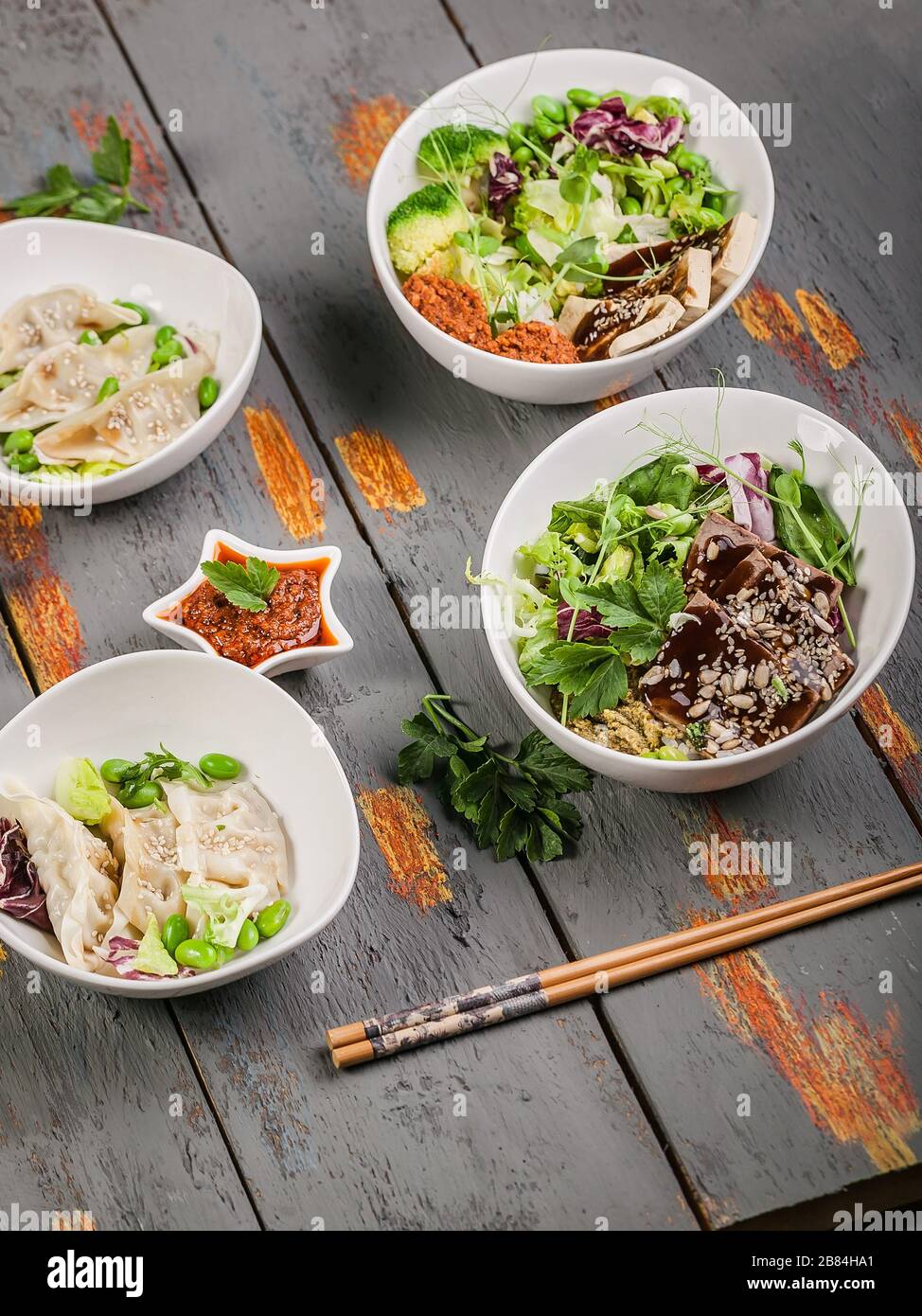 Vertical shot traditional gyozu dumplings, boiled vegetables with rice, pork and spicy sauce. Oriental cuisine Stock Photo