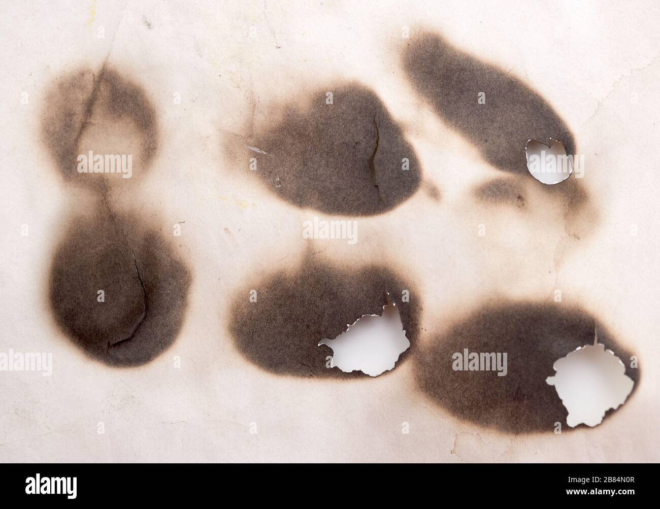 Burnt holes in a paper Stock Photo Alamy