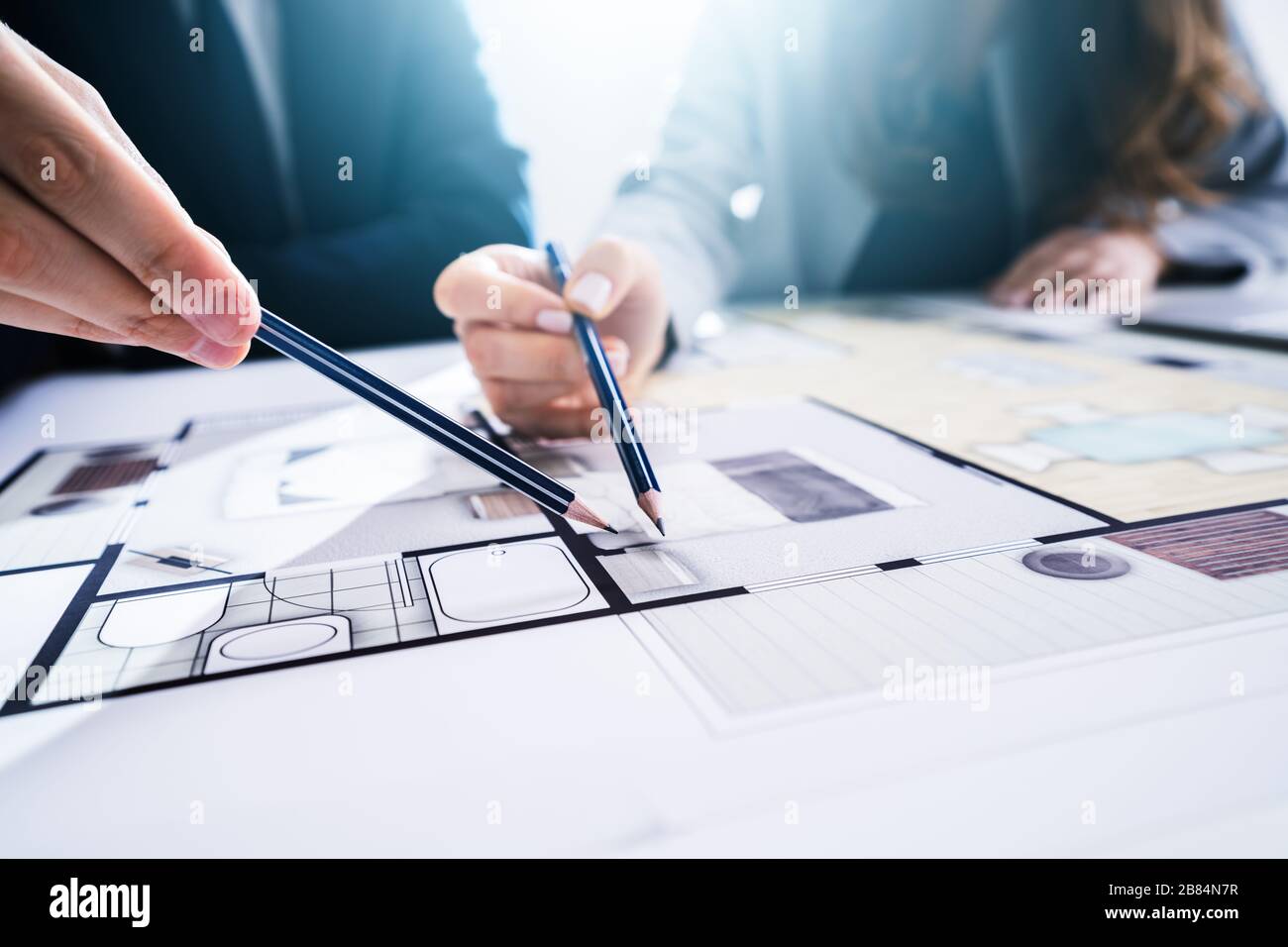 Close-up Of Two Architects Hands Working On Blueprint Stock Photo