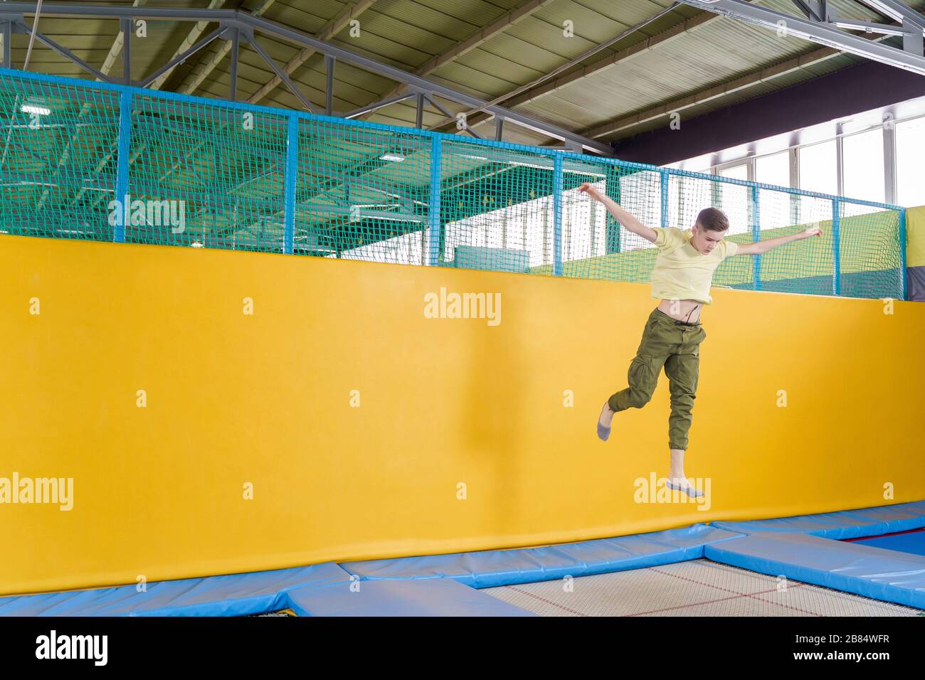 Teenage boy jumping on trampoline park in sport center Stock Photo Alamy