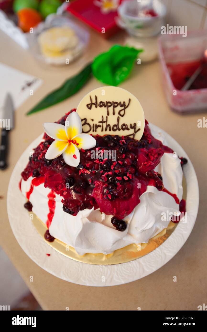 Making Pavlova cake with fruit cream. Greeting celebration happy birthday on cake. Stock Photo