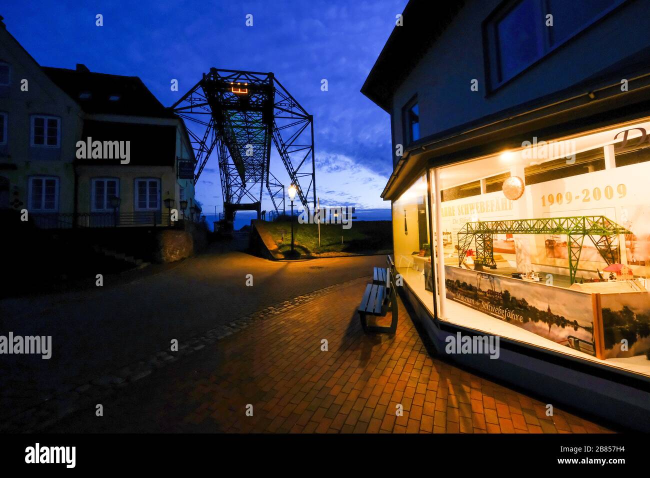 Osten Hemmoor, Germany. 19th Mar, 2020. A floating ferry museum stands in front of the 111-year-old floating ferry, which is illuminated at night. The ferry transports visitors with a gondola from the municipality of Osten across the river Osten to the town of Hemmoor. (To dpa: 'Floating ferry attracts visitors from all over the world: start of season postponed') Credit: Patrik Stollarz/dpa/Alamy Live News Stock Photo