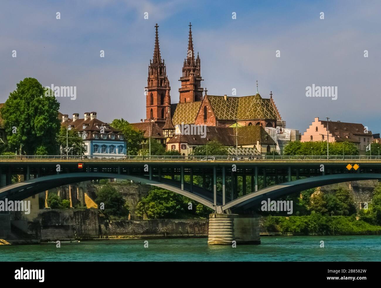Lovely view of the Basler Münster cathedral and the bridge Wettsteinbrücke from the Rhine river. With its red sandstone walls, colourful roof tiles... Stock Photo