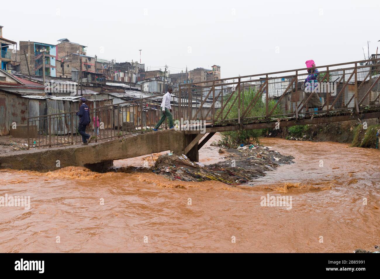 People using a footbridge to cross the Mathare river, Mathare, Nairobi