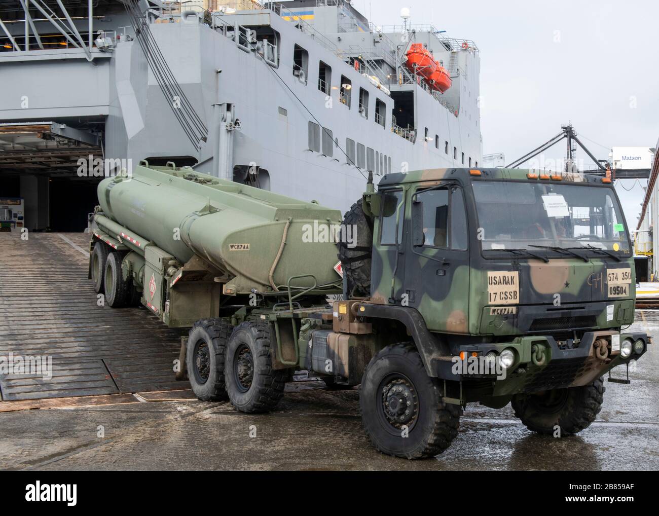 A longshoreman offloads a light medium tactical vehicle from the USNS Bob Hope at the Port of