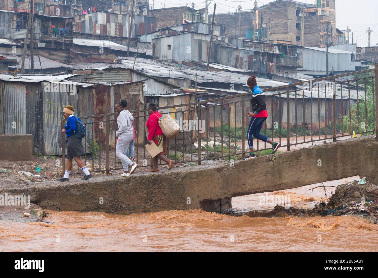 People using a footbridge to cross the Mathare river, Mathare, Nairobi