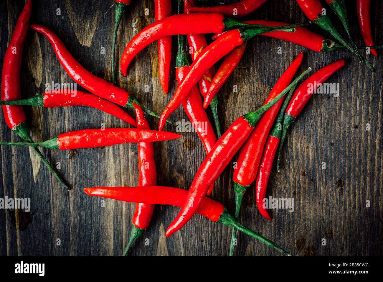 Red hot chili peppers over rustic wooden table - top view Stock Photo ...