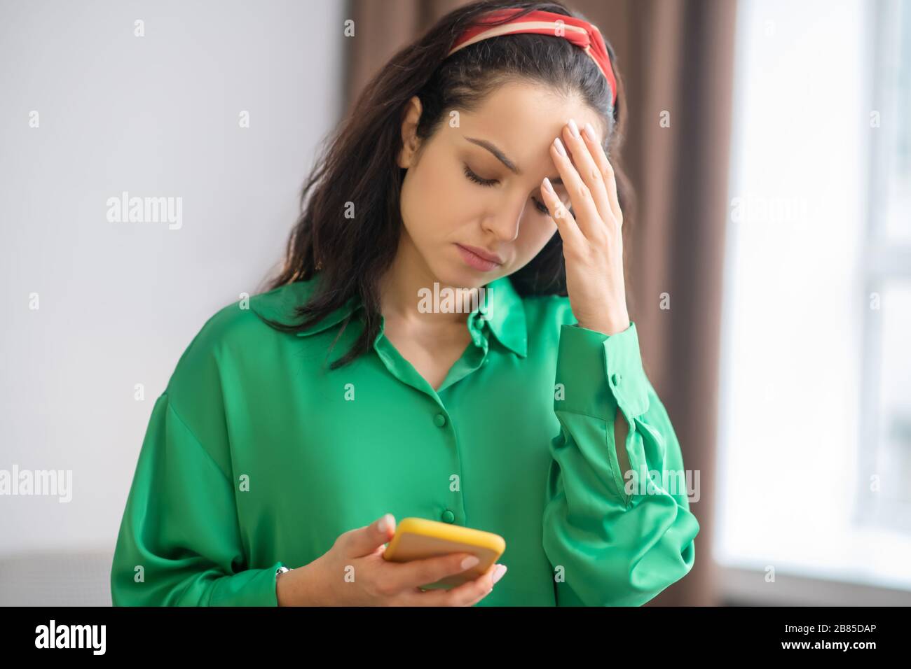 Young upset woman looking at smartphone screen. Stock Photo