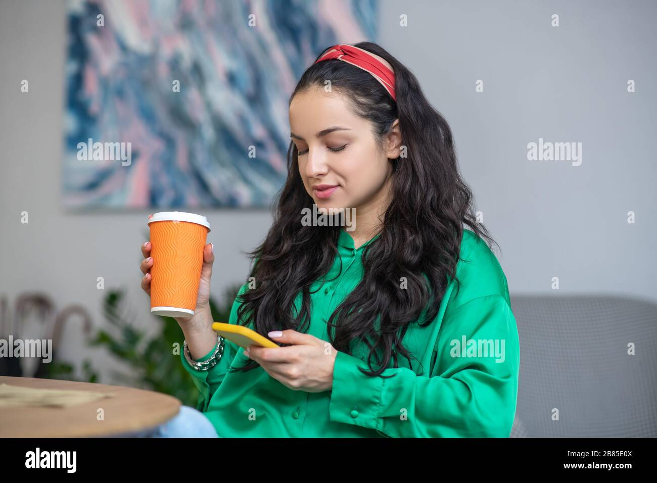Young woman with a smartphone and a glass of coffee. Stock Photo