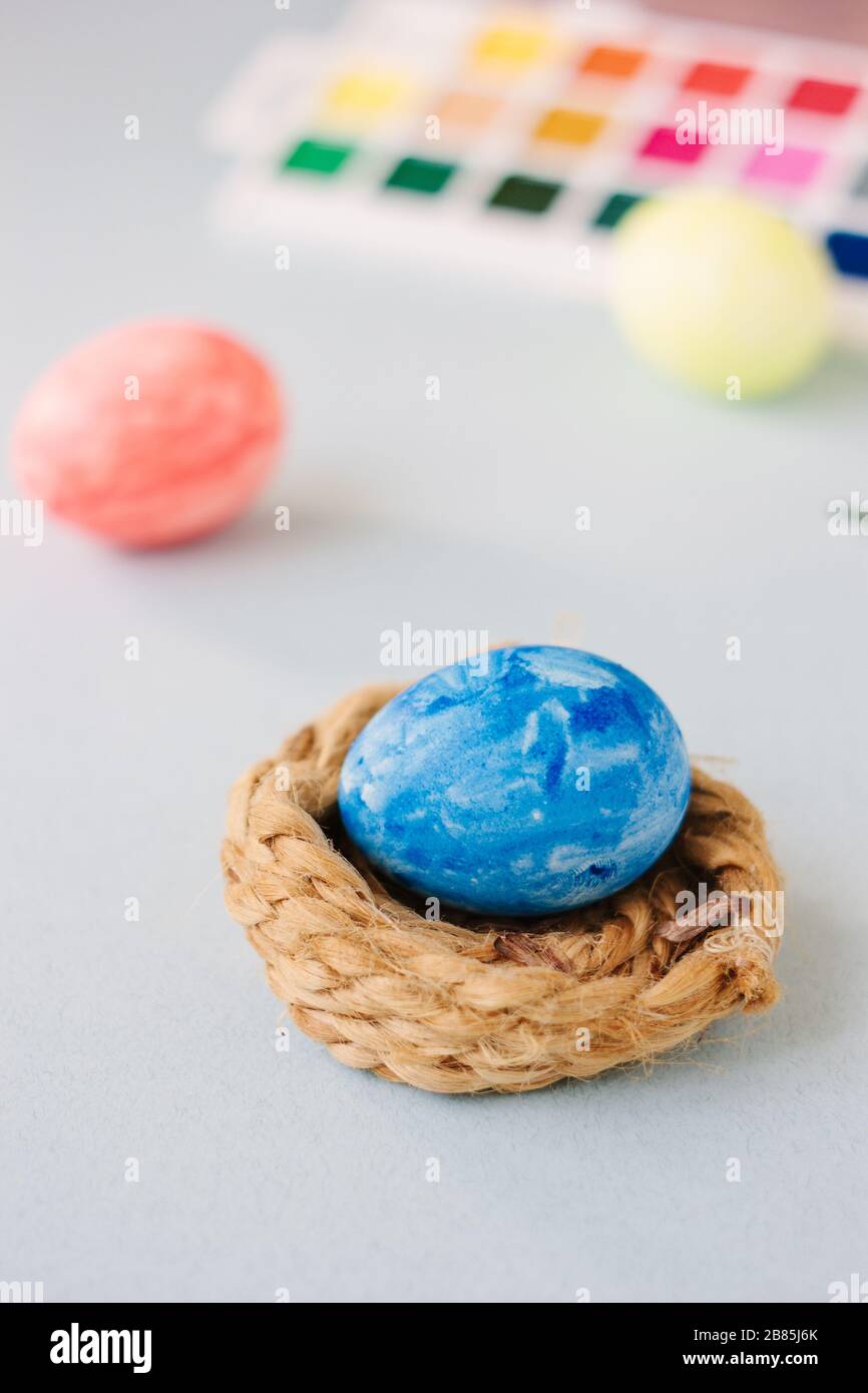 Deep blue easter egg on nest over bright background Stock Photo - Alamy