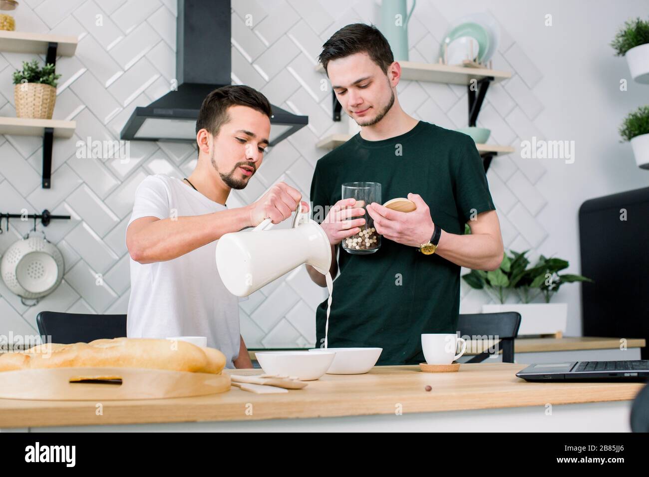 Happy Gay Couple Preparing Breakfast In Kitchen At Morning Handsome Man Putting Breakfast 