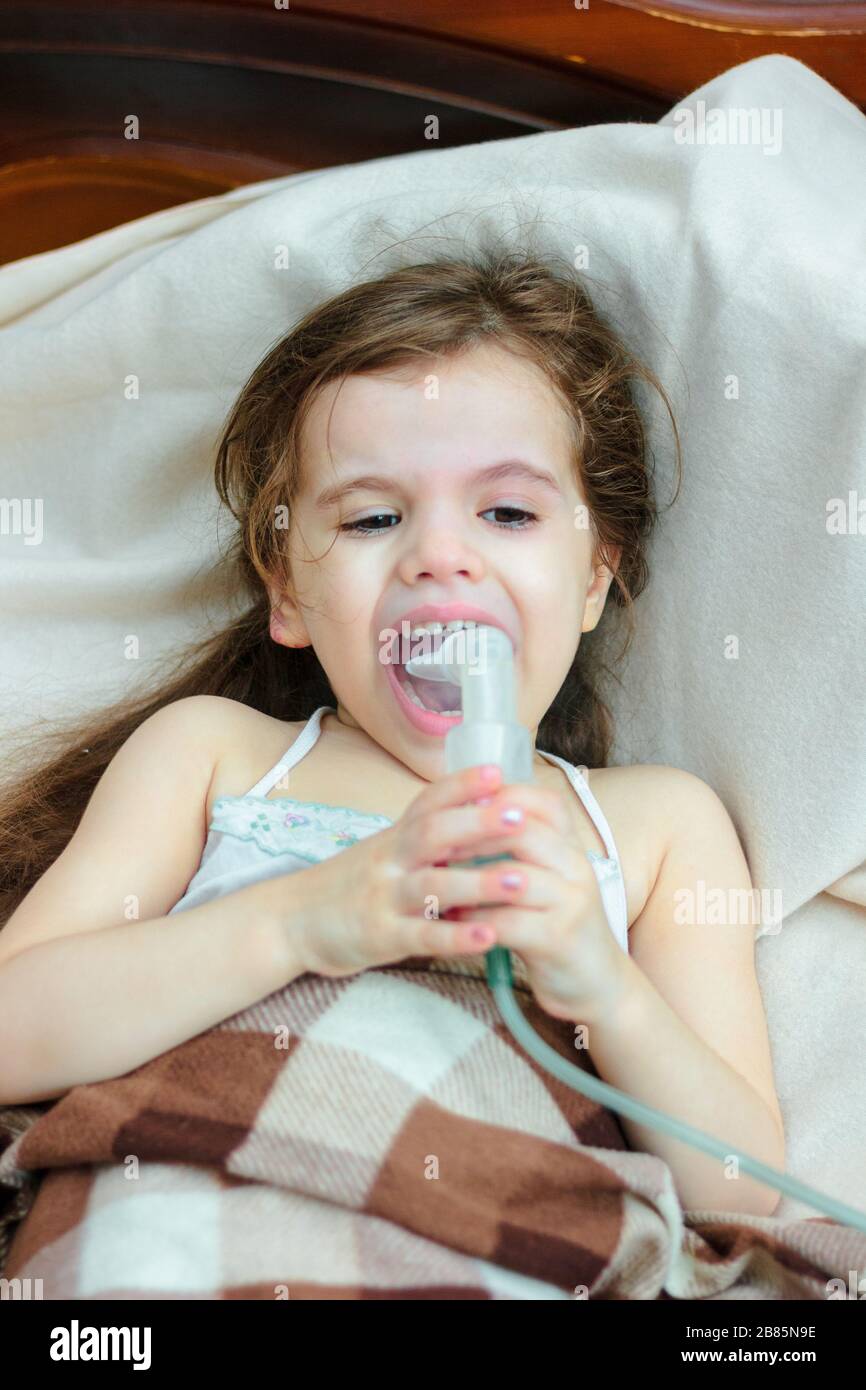 Child with respiratory illness making inhalation with inhaler Stock ...
