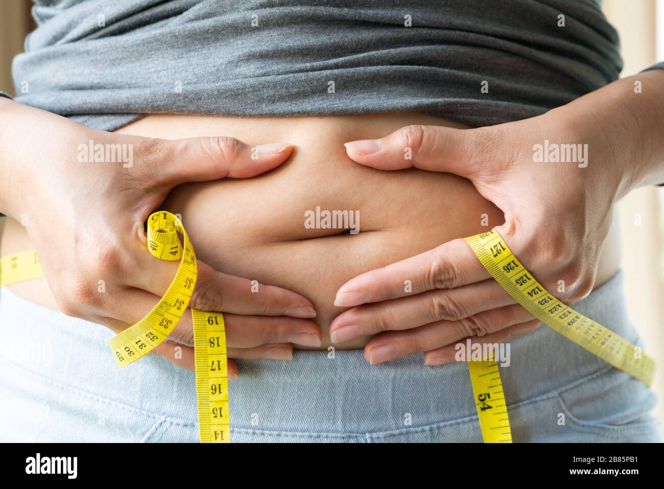 young woman's belly with measurement tape, women diet style concept Stock Photo