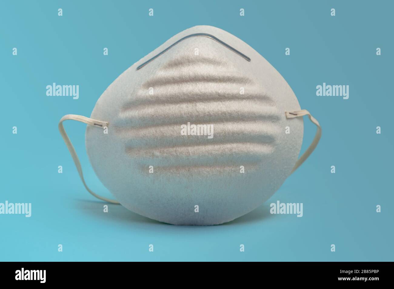 Protective face mask white on blue background Stock Photo