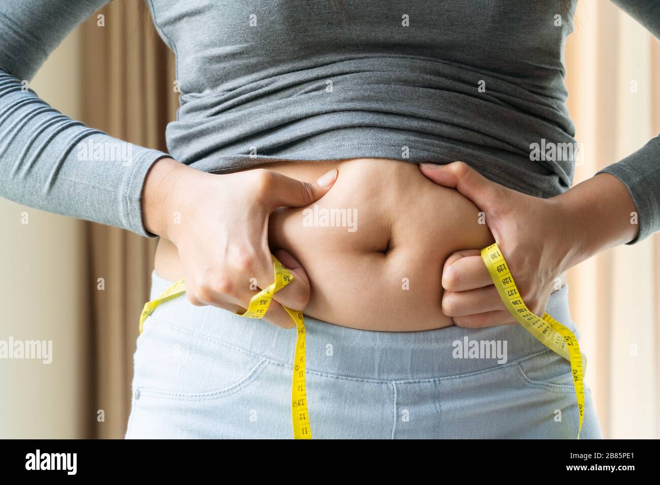 young woman's belly with measurement tape, women diet style concept Stock Photo