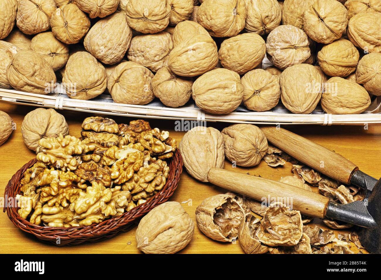 many walnuts in a basket and a little basket full of peeled kernels Stock Photo