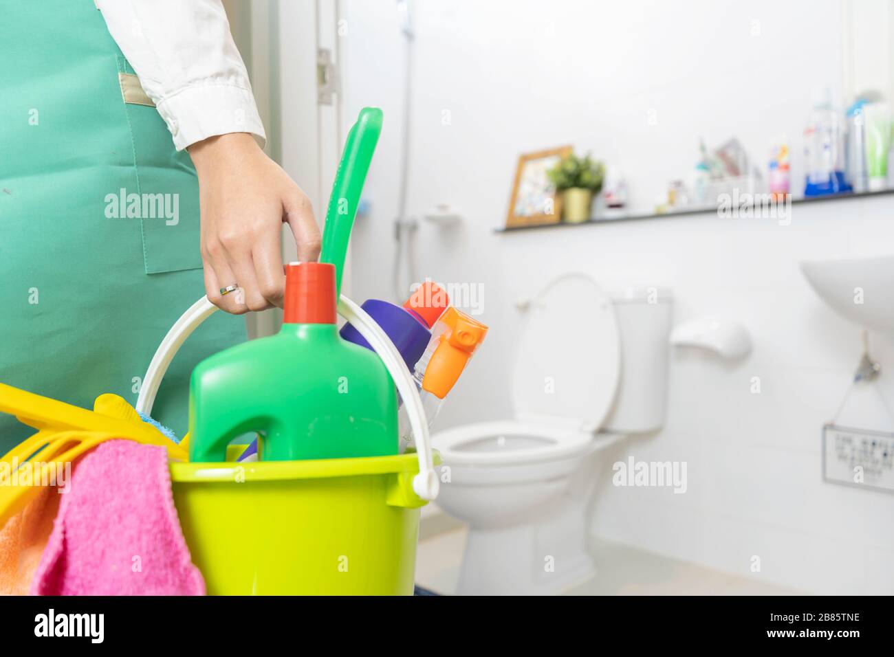 Women carrying a cleaning device to clean the bathroom. The device is ...
