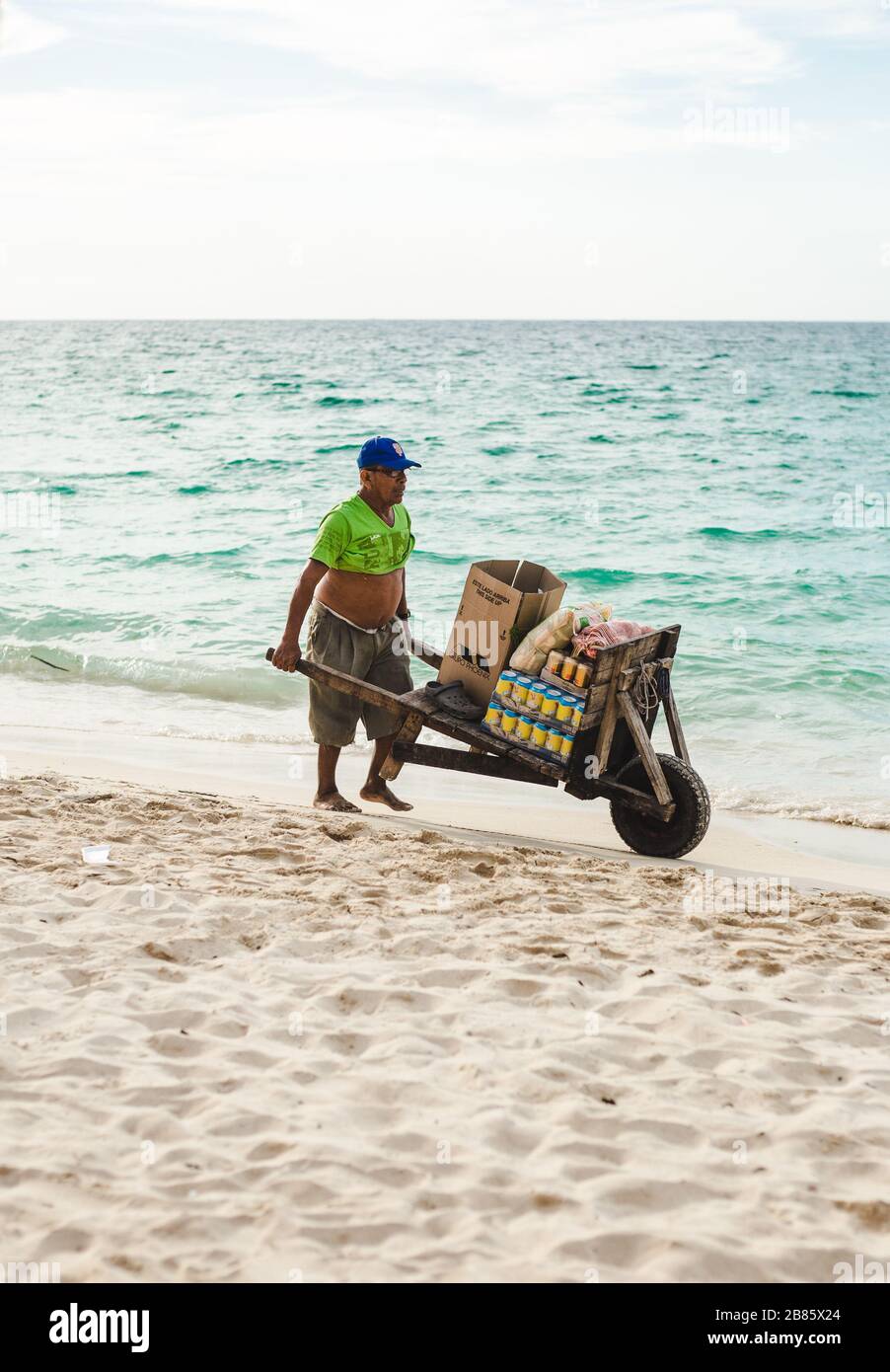Local Colombian vendor sells drinks in cans from his wheelbarrow on the beach of Isla Baru, near Cartagena, Colombia Stock Photo
