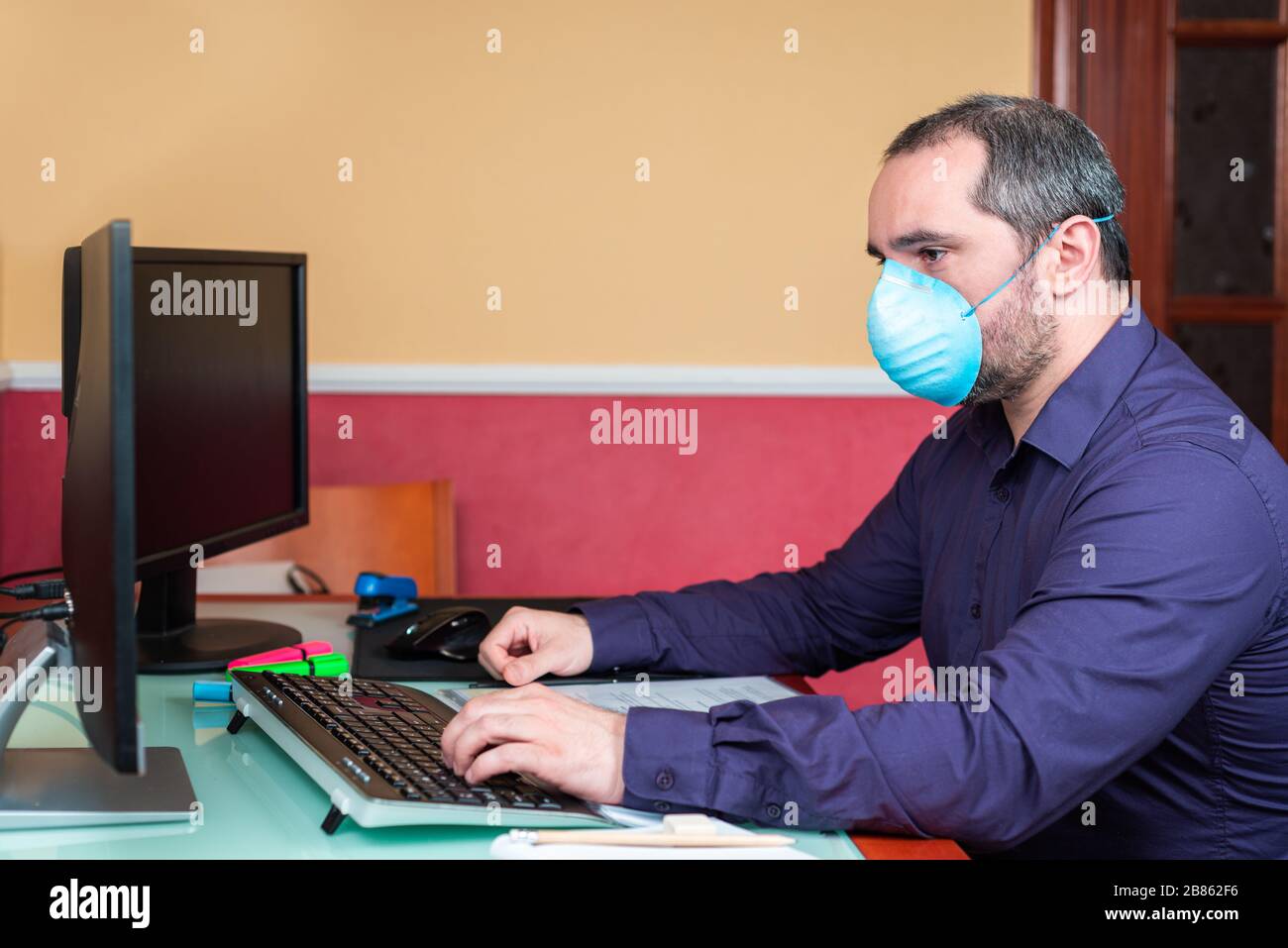 man with medical mask  working in house. Teleworking concept Stock Photo