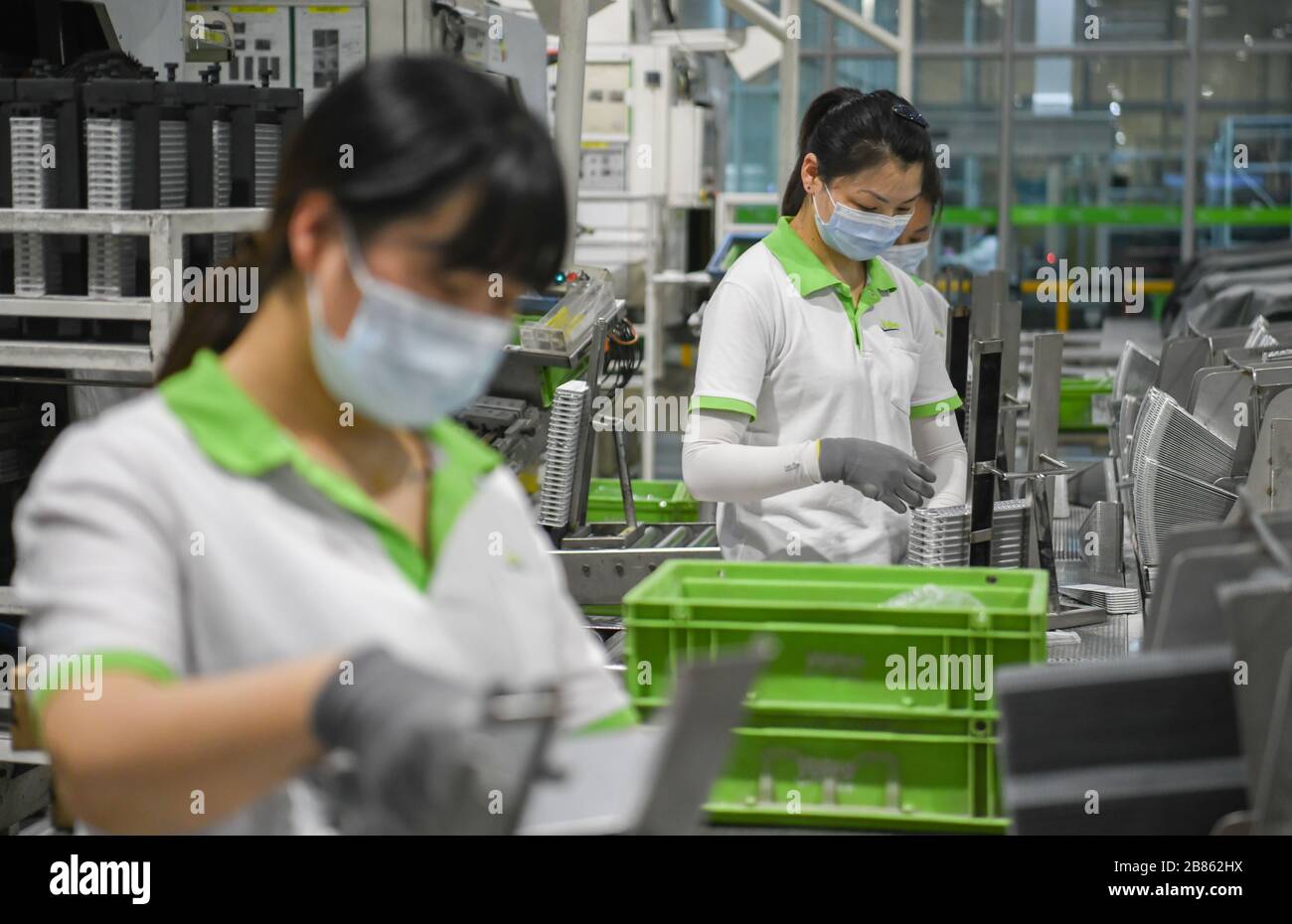 Wuhan, China's Hubei Province. 19th Mar, 2020. Staff members work on a production line at a company in Jingzhou, central China's Hubei Province, March 19, 2020. The Valeo Hubei company has resumed production since late February. Over 90% capacity of the company has recovered and over 80% staff members have returned to their work. Credit: Cheng Min/Xinhua/Alamy Live News Stock Photo