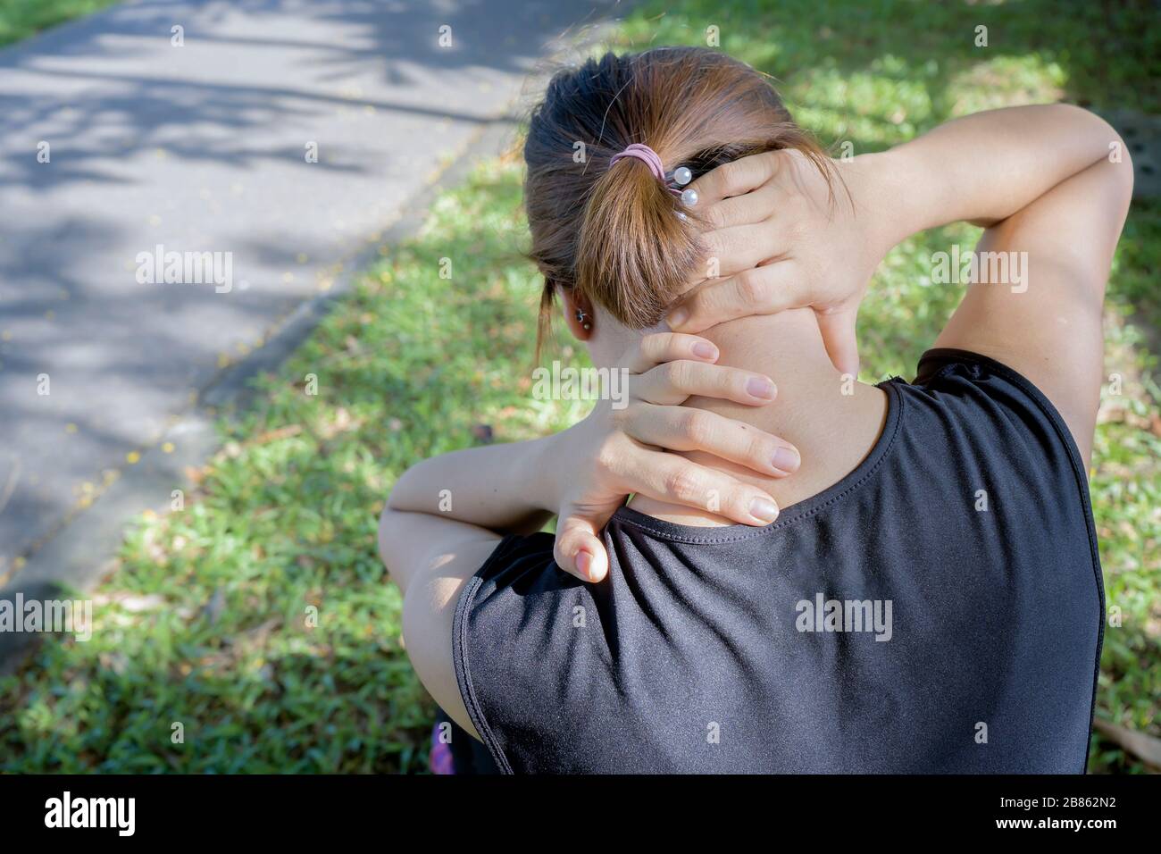 Neck pain during training. woman runner with sport injury in sports bra